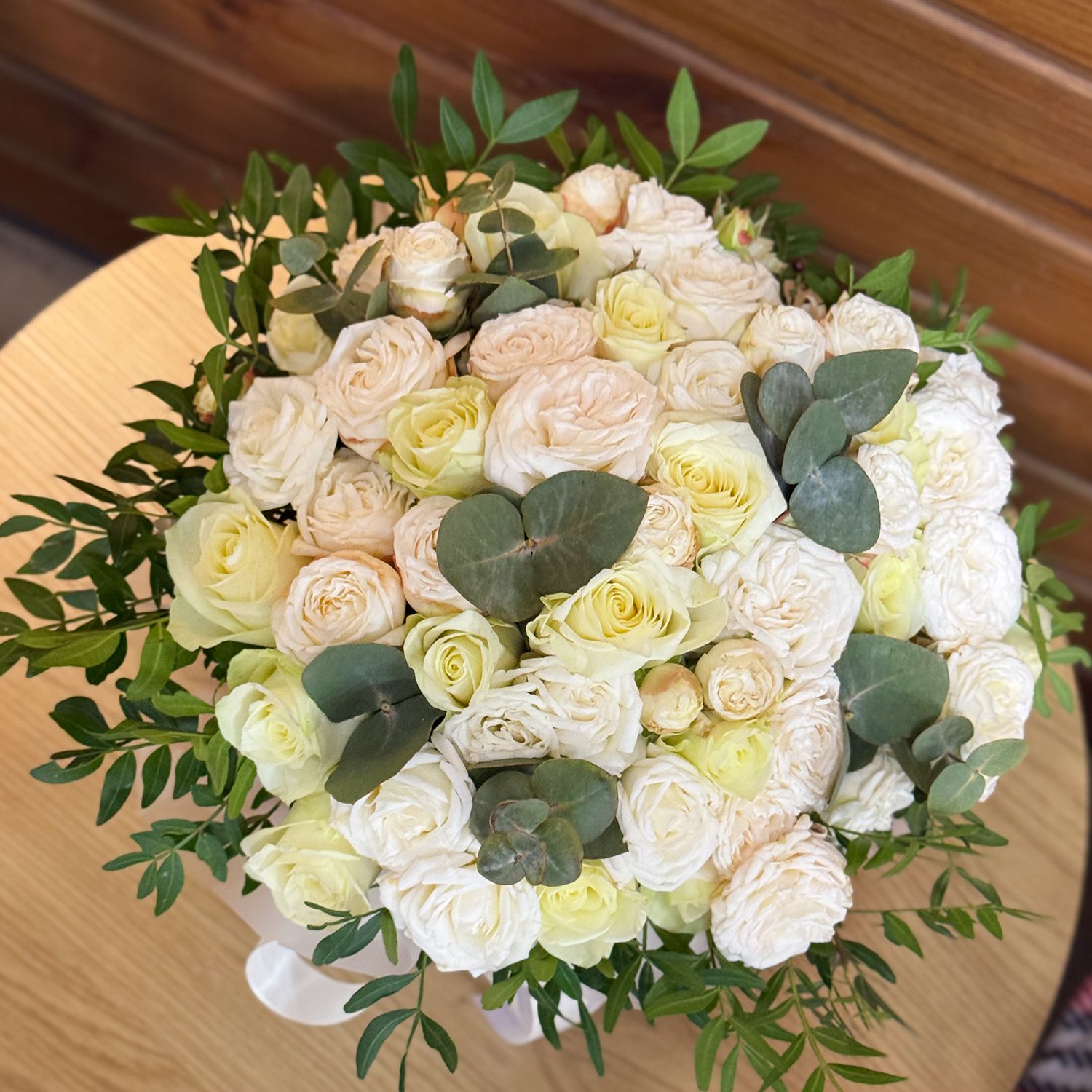 white rose (21 pcs.), cream spray rose (10 pcs.), eucalyptus, decorative elements, oasis, round box, packaging, ribbon